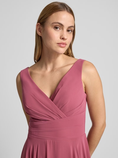 Frauenmodel trägt Maxikleid aus Chiffon in Wickel-Optik von TROYDEN COLLECTION in Altrosa, V-Ausschnitt, glatte Textur, Nahaufnahme Oberkörper.