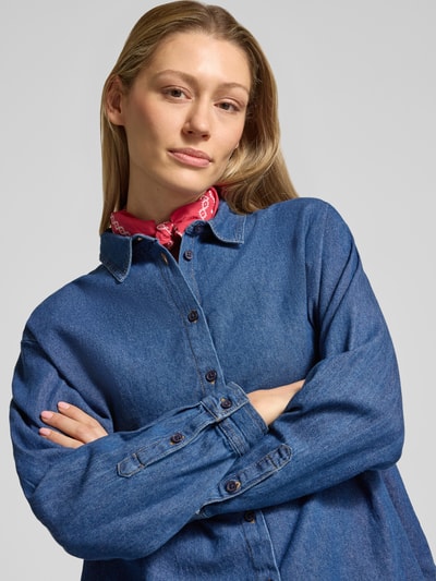 Vrouwenmodel draagt Regular Fit Jeanshemd met hemdblousekraag model 'ARCHER' van ICHI, pure katoen, blauwe kleur, knoopsluiting, detailopname bovenlichaam.