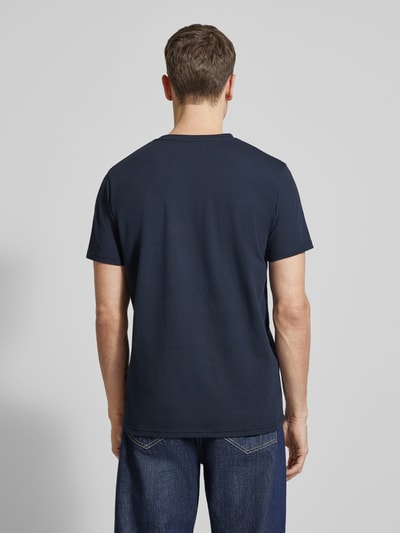 Männermodel trägt T-Shirt mit Label-Print Modell 'Jeramy' von Matinique aus Baumwoll-Elasthan-Mix in Dunkelblau, Ganzkörperansicht Rückansicht.