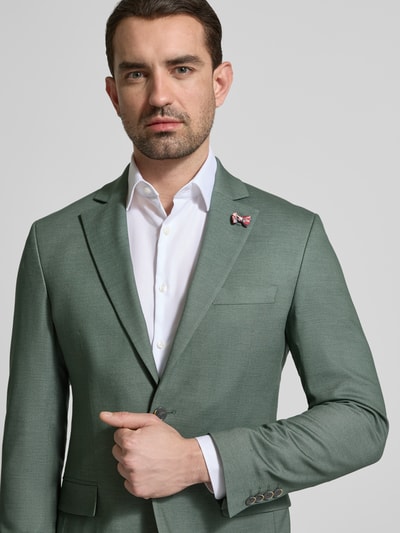 Männermodel trägt Slim Fit 2-Knopf-Sakko mit Pattentaschen von ATELIER TORINO in Grün, Material-Mix mit Viskose, Nahaufnahme Oberkörper.
