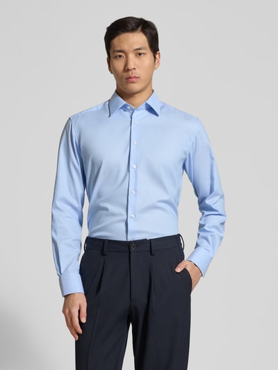 Männermodel trägt Regular Fit Business-Hemd mit Kentkragen von ETERNA in Hellblau, reine Baumwolle, Ganzkörperansicht von vorne.
