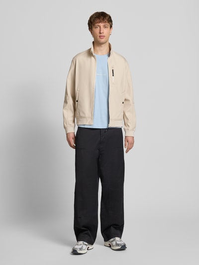 Männermodel trägt Regular Fit Bomberjacke mit Stehkragen Modell 'Parker' von Jack & Jones, Softshell, beige, Ganzkörperansicht von vorne.