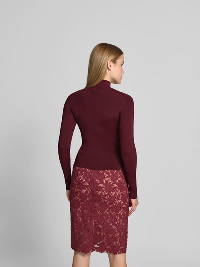 Frauenmodel trägt Slim Fit Longsleeve aus Viskose-Mix von Self-Portrait in Dunkelrot mit Rollkragen, Zierbesatz und Cut-Outs, Ganzkörperansicht Rückansicht.