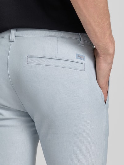 Mannenmodel draagt Slim Fit Chino aus Baumwoll-Mix mit Leinen und Viskose-Anteil Modell 'Chino-Slim-2' van BOSS Orange in licht denimkleur, twillstructuur, label patch, achterzak, detailopname rugzijde