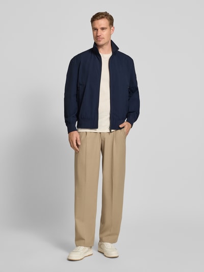 Männermodel trägt Relaxed Fit Blouson aus wasserabweisendem Material Modell 'OPENS' von BOSS Orange, Optik: Unifarben, Stehkragen, Zweiwege-Reißverschluss, Label-Patch, Langarm, Ärmelabschluss: Gerippt, Rumpfabschluss: Gerippt, seitliche Eingrifftaschen, Ganzkörperansicht von vorne.