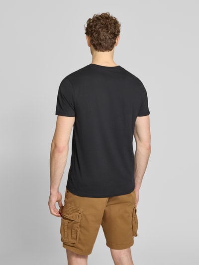 Männermodel trägt T-Shirt mit Logo-Patch und Rundhalsausschnitt von GAP, Reine Baumwolle, Straight Fit, Rückenlänge 70 cm, Ganzkörperansicht Rückansicht.