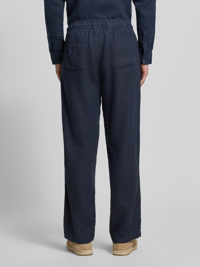 Männermodel trägt Leinenhose mit elastischem Bund von MCNEAL in Dunkelblau, Regular-Fit, Reine Leinen, Ganzkörperansicht Rückansicht.