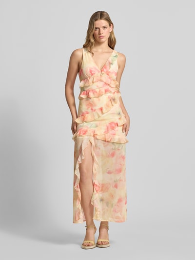 Vrouwenmodel draagt maxi-jurk met ruches van Gina Tricot, nauwsluitend, bloemenprint, V-hals, mouwloos design, loopsplit, all-over print. Ganzkörperansicht van voren.
