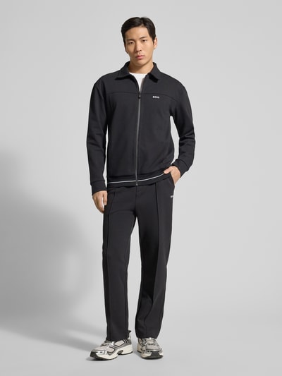 Männermodel trägt schwarze Regular Fit Sweatjacke aus Baumwoll-Mix Modell 'SW_Member' von BOSS Green, Ganzkörperansicht von vorne.