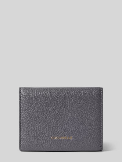 Produktfoto, Portemonnaie mit Label-Detail von Coccinelle in Dunkelgrau mit Strukturmuster, metallic Label, Verschluss mit Druckknopf, Münzfach und mehreren Fächern