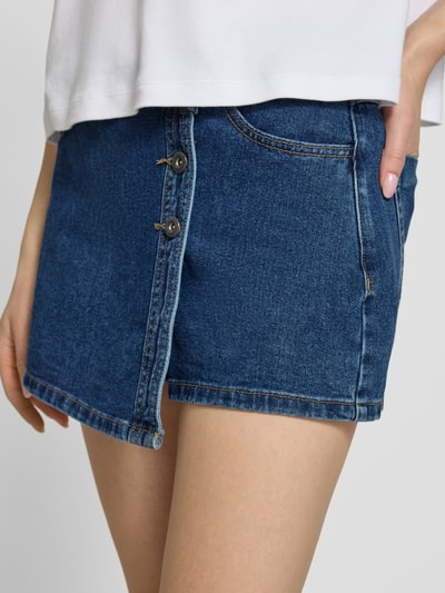 Frauenmodel trägt Regular Fit Jeansskort aus reiner Baumwolle Modell 'LESLY' von Only, Denim-Optik, Eingrifftaschen, Nahaufnahme Oberschenkel.