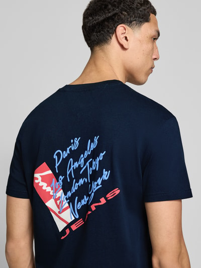 Männermodel trägt Regular Fit T-Shirt aus reiner Baumwolle von Tommy Jeans in Optik: Unifarben, Label-Print, Ganzkörperansicht Rückansicht.