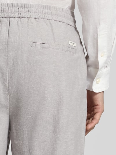 Männermodel trägt Jogpants aus Baumwoll-Leinen-Mix Modell 'WARREN' von Scotch & Soda, hellgrau, elastischer Bund, Detailaufnahme, Regular-Fit, Bundweite 41 cm, Innenbeinlänge 75 cm bei Größe 32/32.