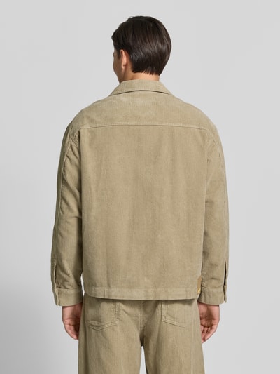 Mannenmodel draagt Relaxed Fit vrijetijdsoverhemd van pure katoen van ARMEDANGELS in beige met cordstructuur, geheellichaamsaanzicht achterkant.