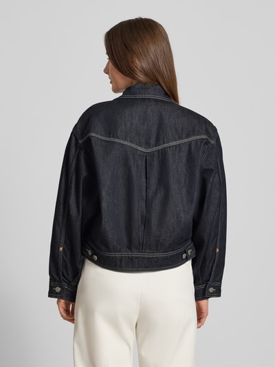 Frauenmodel trägt Regular Fit Jeansjacke aus Baumwoll-Lyocell-Mix Modell 'BOMBER TRUCKER 1.0' von BOSS Orange, Denim-Optik, Rückenpasse, Ganzkörperansicht Rückansicht.