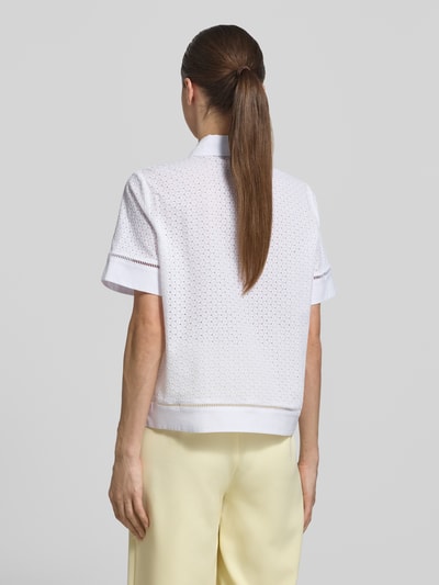 Frauenmodel trägt Regular Fit Bluse mit Lochstickerei Modell 'Blanc' von JOOP! aus weißer Baumwolle, Rückansicht, Ganzkörperansicht.