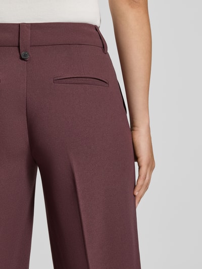 Frauenmodel trägt Regular Fit Weite Hose mit Bügelfalten Modell 'KALINA' von ONLY in Dunkelrot, glatte Textur, Nahaufnahme Hüfte, Damen Weite Hose von ONLY