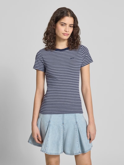 Modelka nosi Slim Fit T-Shirt aus reiner Baumwolle von Levi's®, paski, łatka z logo, okrągły dekolt, krótkie rękawy, bawełna, krój slim fit, widok z przodu na całą sylwetkę