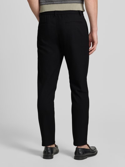 Männermodel trägt Slim Fit Stoffhose mit Viskose-Anteil von Lindbergh, Schwarz mit Strukturmuster, Bundfalten, Gesäßtaschen, Eingrifftaschen, Elastischer-Material-Mix, Tunnelzug, Knopf- und Reißverschluss, Bundweite 41 cm, Innenbeinlänge 76 cm, Ganzkörperansicht Rückansicht.