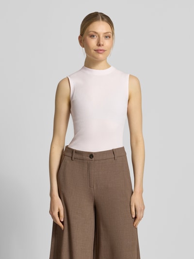 Frauenmodel trägt Slim Fit Top mit Mock-Neck Modell 'FESKIES' von BOSS in Unifarbe aus Viskose-Mix Rippstrick, Ganzkörperansicht von vorne.