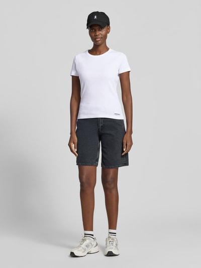 Frauenmodel trägt Damen T-Shirt Slim Fit T-Shirt aus Baumwoll-Mix Modell 'KARDAA' von Armedangels, Optik: Unifarben, Logo-Stitching, Rundhals, Kurzarm, Materialverarbeitung: Feinripp, Ganzkörperansicht von vorne.