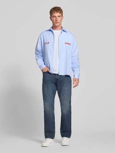 Männermodel trägt Relaxed Fit Langarmshirt aus Baumwoll-Mix Modell 'SCASPIAN' von ONLY, hellblau, kombiniert mit Jeans, Ganzkörperansicht von vorne, Herren T-Shirt von ONLY & SONS.