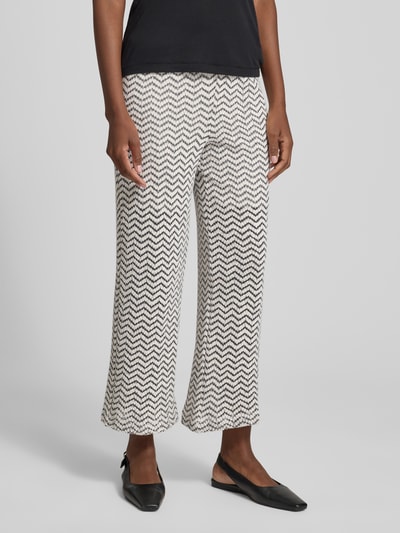Vrouwenmodel draagt 'Schlupfhose im Allover-Look mit Tunnelzug' van comma, regular fit, elastische band, all-over look, tunnelkoord, zwart-wit zigzagpatroon, bandwijdte maat 36: 38 cm, binnenbeenlengte maat 36: 73 cm, volledige vooraanzicht.