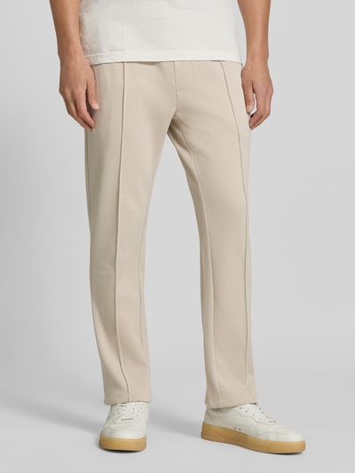 Männermodel trägt Straight Fit Hose mit Baumwoll-Anteil Modell 'Parker' von MCNEAL in Beige, elastischer Bund, Nahaufnahme Unterkörper. Material-Mix, Gesäßtasche, Innenbeinlänge 73 cm in Größe M.