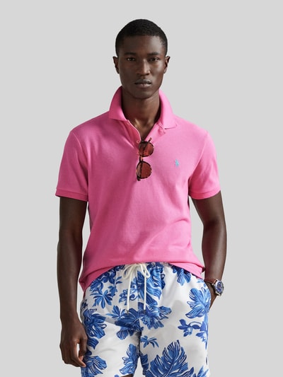 Männermodel trägt Regular Fit Poloshirt aus reiner Baumwolle von Polo Ralph Lauren in Pink mit Logo-Detail, Ganzkörperansicht von vorne.