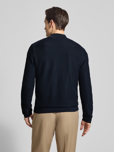 Męski model nosi Regular Fit Cardigan mit Stehkragen od OLYMP Level Five z bawełny, imitacja dzianiny, zamek błyskawiczny, elastyczne wykończenia, długość tyłu 68 cm, długość rękawów 67 cm, widok całej sylwetki od tyłu.