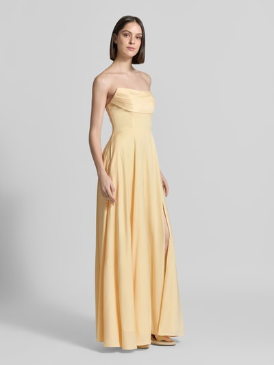 Frauenmodel trägt Maxikleid im Off-Shoulder-Look von Luxuar in Hellgelb, Taillierter Schnitt, Gehschlitz, Rückseitige Schnürung, Ganzkörperansicht von vorne, Rückenlänge bei Größe 36: 134 cm, Brustweite bei Größe 36: 43 cm.