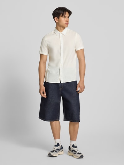 Männermodel trägt Regular Fit Freizeithemd mit Kentkragen Modell 'ABAN' von Blend in Weiß, halbarm, glatte Struktur, Ganzkörperansicht von vorne.