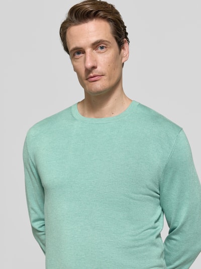 Männermodel trägt Strickpullover mit geripptem Rundhalsausschnitt von MCNEAL in Mintgrün, taillierte Passform, Nahaufnahme Oberkörper.