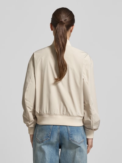 Männermodel trägt Regular Fit Jacke mit Stehkragen von camel active, beżowy kolor, gładka tekstura, proste linie, krój regular fit, długość tyłu w rozmiarze 36: 55 cm, szerokość ramion w rozmiarze 36: 43 cm, szerokość klatki piersiowej w rozmiarze 36: 53 cm, długość rękawa w rozmiarze 36: 59 cm, widok całej sylwetki z tyłu