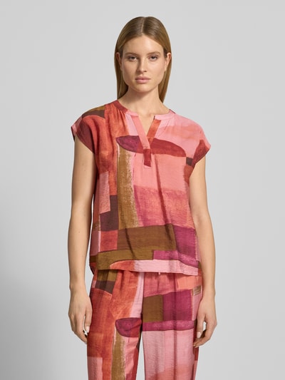 Vrouwenmodel draagt dames blouse van viscosemix, regular fit, model 'Catania' van Soyaconcept, tuniekhals, kapmouwen, kleurrijk abstract patroon, ruglengte maat S 55 cm, mouwlengte 20 cm, vooraanzicht bovenlichaam.