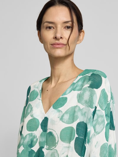 Frauenmodel trägt Relaxed Fit Bluse im Allover-Look von Apricot mit grünem Punktmuster auf fließendem Viskose-Mix, Nahaufnahme Oberkörper.