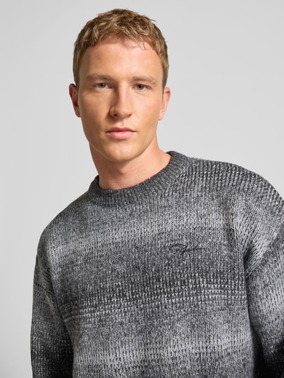 Męski model nosi Oversized Strickpullover mit gerippten Abschlüssen od Pegador, melanż szarości, okrągły dekolt, zbliżenie na górną część ciała.