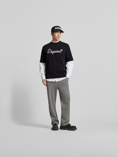 Männermodel trägt Loose Fit T-Shirt aus reiner Baumwolle von Dsquared2 in Schwarz mit Label-Stitching, Ganzkörperansicht von vorne.