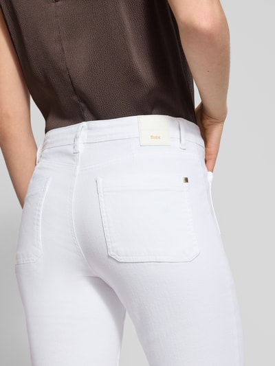 Kobiece modelka nosi Flared Fit Jeans mit Flecht-Detail Modell 'Mary' od Brax, biały elastyczny bawełniany materiał, kieszenie naszywane i z tyłu, guzikiem i zamkiem, szerokość w rozmiarze 36: 39 cm, długość wewnętrzna nogawki 80 cm, zbliżenie na tył