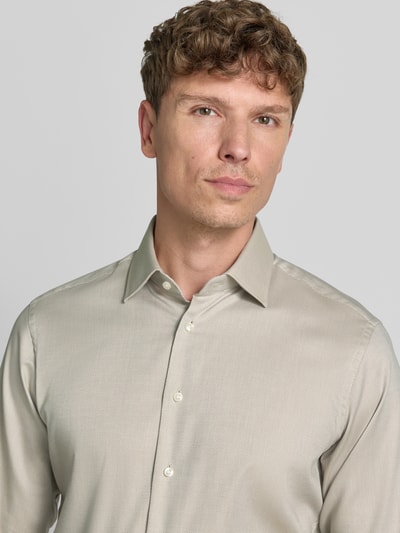 Männermodel trägt Regular Fit Business-Hemd mit Kentkragen van Christian Berg Men, beige kleur, katoen, lange mouw, knoopsluiting, nahaufnahme oberkörper.