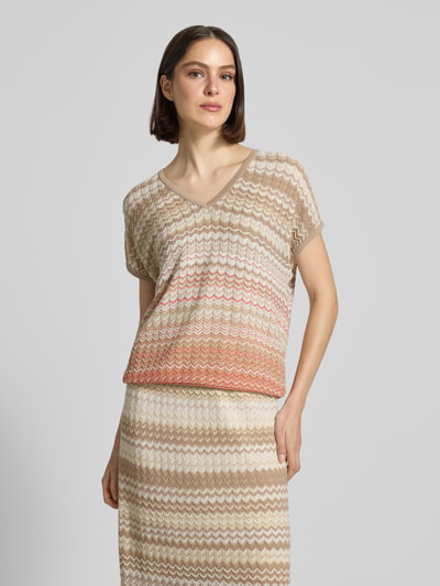 Frauenmodel trägt Strickshirt mit V-Ausschnitt und Kappärmeln Modell 'Shani' von MOS MOSH aus Baumwoll-Mix, Loose-Fit, mehrfarbiges Zickzackmuster, Rückenlänge bei Größe S: 60 cm, Ganzkörperansicht von vorne.
