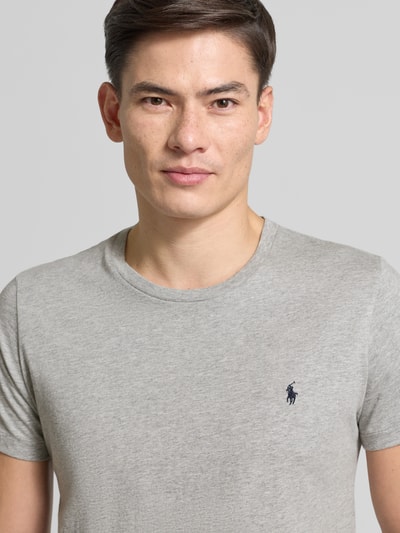Männermodel trägt T-Shirt mit Logo-Stitching von Polo Ralph Lauren aus reiner Baumwolle, gerade Passform, Rundhalsausschnitt, Nahaufnahme Oberkörper.