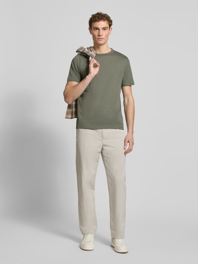 Männermodel trägt Regular Fit T-Shirt aus reiner Baumwolle Modell 'TEGOOD' von BOSS Orange in Olivgrün, unifarben, Rundhals, Ganzkörperansicht von vorne.