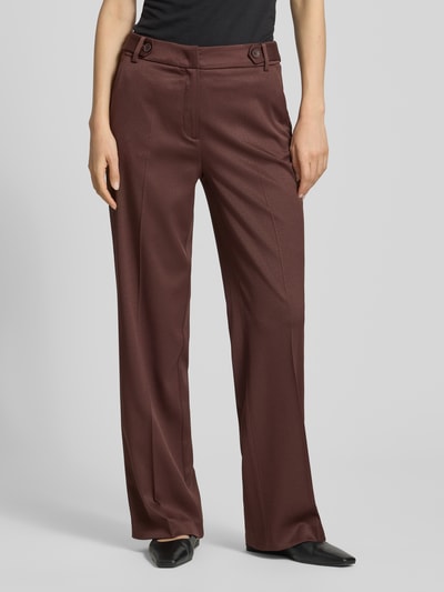 Frauenmodel trägt Wide Fit Stoffhose mit Viskose-Anteil von More & More in Braun mit Bügelfalten, Strukturmuster und Haken-Reißverschluss, Elastischer-Material-Mix, Bundweite 37 cm, Innenbeinlänge 80 cm, Ganzkörperansicht von vorne.