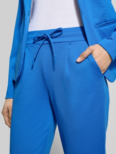 Frauenmodel trägt Slim Fit Stoffhose mit Viskose-Anteil Modell 'Kate' von ICHI in kräftigem Blau, elastischer Bund mit Tunnelzug, Eingrifftaschen, Bundfalten, elastischer Material-Mix, Nahaufnahme Oberkörper.