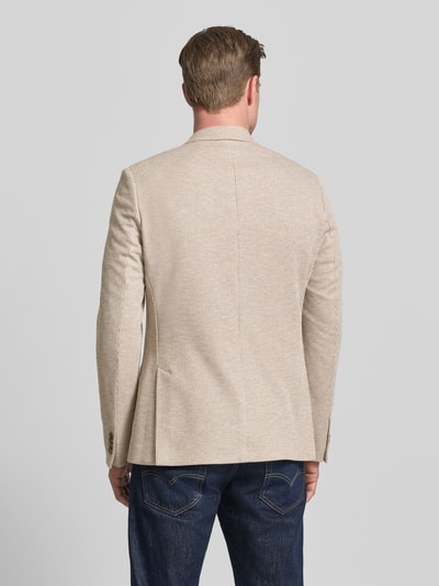 Mężczyznamodel nosi Slim Fit 2-Knopf-Sakko mit Reverskragen von Roy Robson, mieszanka bawełny, nakładane kieszenie, długość tyłu 74 cm, szerokość ramion 43 cm, długość rękawów 67 cm, kolor beżowy z delikatną teksturą, krój slim fit, widok całej sylwetki z tyłu.