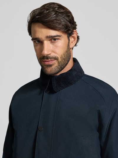 Männermodel trägt Regular Fit Funktionsjacke mit Kapuze von Barbour, unifarben matt, Strukturmuster, Nahaufnahme Oberkörper.