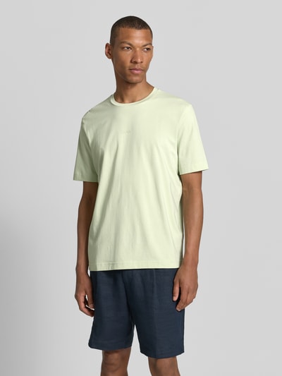 Männermodel trägt hellgrünes Regular Fit T-Shirt aus Baumwoll-Mix Modell 'TCHUP' von BOSS für BOSS Orange, Ganzkörperansicht von vorne.