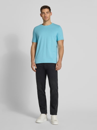 Męski model nosi Regular Fit T-Shirt aus reiner Baumwolle od s.Oliver RED LABEL, kolor jednolity, krój regular fit, nadruk z logo, okrągły dekolt, krótki rękaw, dzianina, bawełna, widok całej sylwetki z przodu.