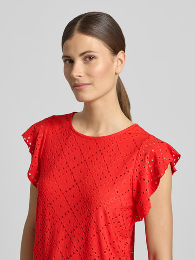Frauenmodel trägt Damen T-Shirt von Vero Moda, Modell 'TASSA' in Optik: Unifarben, Regular-Fit, Rundhals-Ausschnitt, Ärmelform: Kurzarm, Ärmelabschluss: Frill, Materialverarbeitung: Stretch, leuchtend rot mit durchbrochenem Muster, Nahaufnahme Oberkörper.